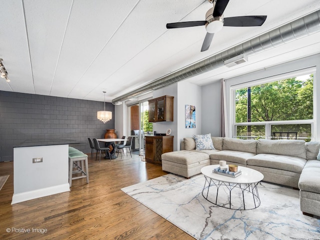 1100 W Montrose Ave Unit 207, Chicago, IL 60613 - living room featuring wood finished floors, healthy amount of natural light, ceiling fan, and a chandelier