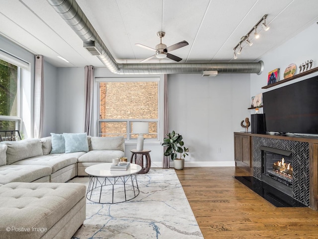 1100 W Montrose Ave Unit 207, Chicago, IL 60613 - living room featuring a ceiling fan, wood finished floors, a fireplace with flush hearth, and rail lighting