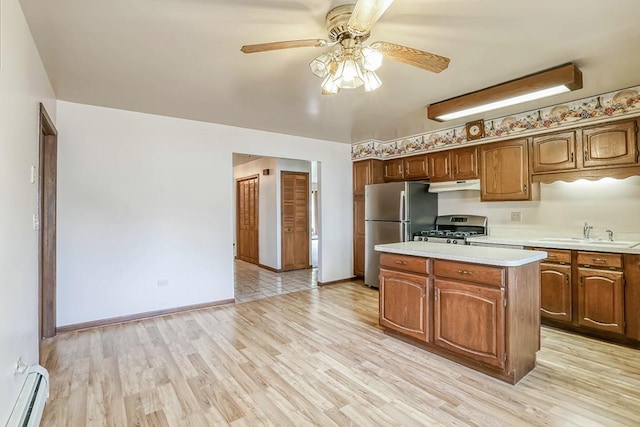 1310 Vinewood Ave, Willow Springs, IL 60480 - kitchen with a baseboard radiator, range with gas cooktop, freestanding refrigerator, light countertops, and under cabinet range hood