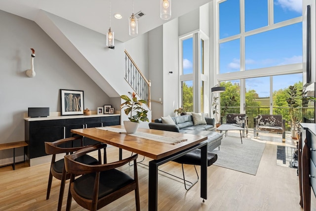 2047 N Leavitt St Unit 2N, Chicago, IL 60647 - dining space with stairway, a towering ceiling, and light wood-style flooring