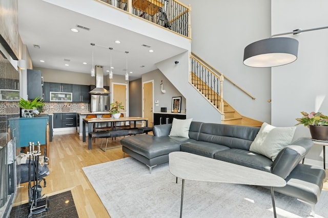 2047 N Leavitt St Unit 2N, Chicago, IL 60647 - living room with light wood-style floors, stairs, a towering ceiling, and recessed lighting