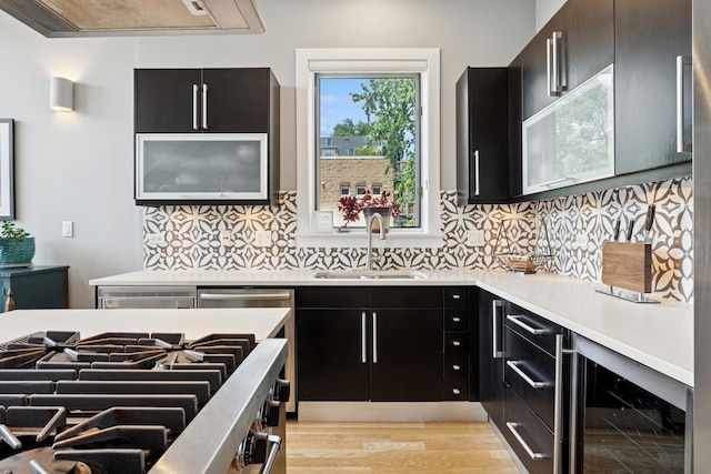 2047 N Leavitt St Unit 2N, Chicago, IL 60647 - kitchen featuring beverage cooler, dark cabinetry, stovetop, light countertops, and tasteful backsplash