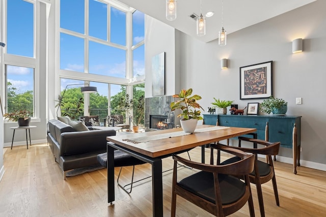 2047 N Leavitt St Unit 2N, Chicago, IL 60647 - dining space with a high ceiling, a warm lit fireplace, plenty of natural light, and light wood-style flooring