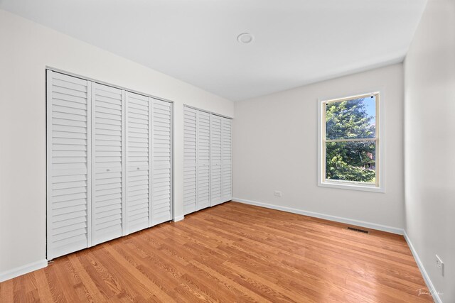6730 Revere Rd, Downers Grove, IL 60516 - unfurnished bedroom with light wood-style floors and multiple closets