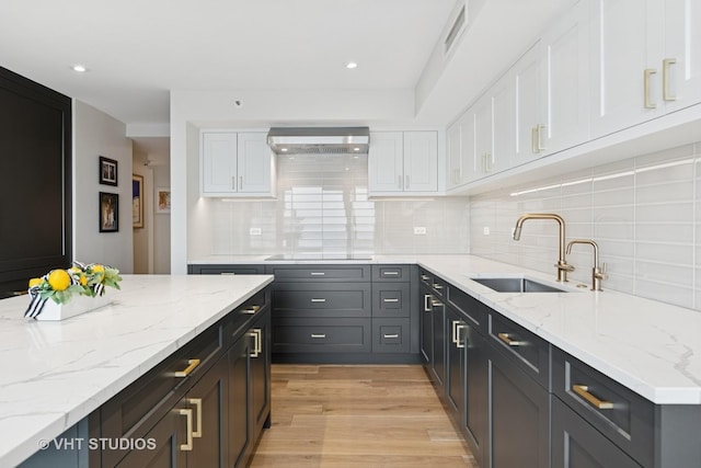 132 E Delaware Pl Unit 5101, Chicago, IL 60611 - kitchen with white cabinets, black electric stovetop, light stone counters, backsplash, and recessed lighting