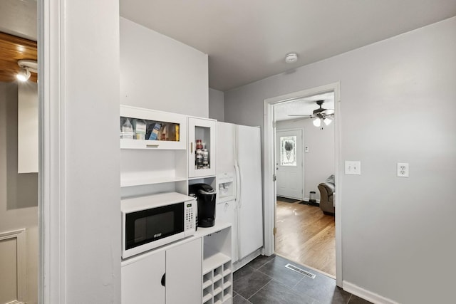 1118 Somonauk St, Sycamore, IL 60178 - kitchen with white microwave, white cabinetry, light countertops, ceiling fan, and glass insert cabinets