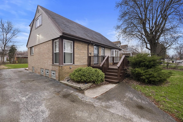 15607 Rose Dr, South Holland, IL 60473 - view of side of home featuring a wooden deck, roof with shingles, brick siding, and stone siding