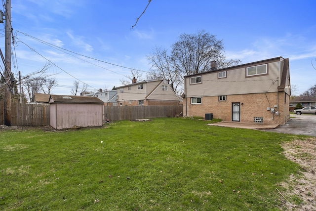 15607 Rose Dr, South Holland, IL 60473 - back of property with brick siding, a storage unit, a fenced backyard, and a patio