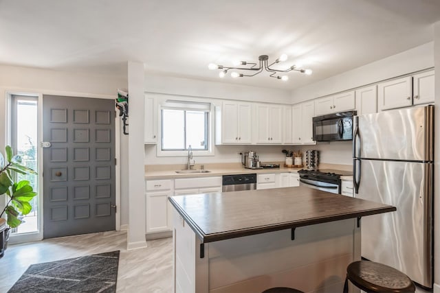 6221 N Niagara Ave Unit 507, Chicago, IL 60631 - kitchen featuring appliances with stainless steel finishes, white cabinets, a breakfast bar, butcher block countertops, and a kitchen island