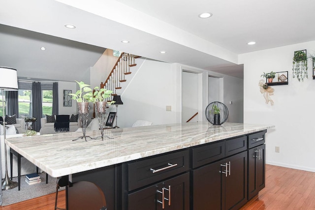 3 Laurel Ct, Galena, IL 61036 - kitchen with light wood-type flooring, a kitchen breakfast bar, recessed lighting, light stone countertops, and open floor plan