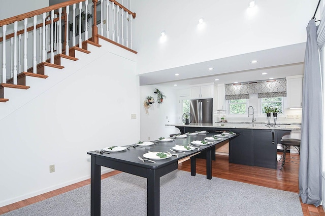 3 Laurel Ct, Galena, IL 61036 - kitchen with freestanding refrigerator, light wood finished floors, light countertops, white cabinetry, and a breakfast bar