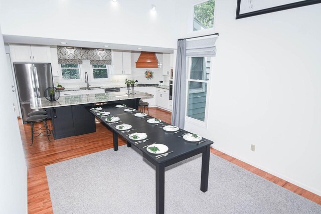 3 Laurel Ct, Galena, IL 61036 - kitchen with white cabinetry, custom range hood, stainless steel appliances, and light wood-style flooring