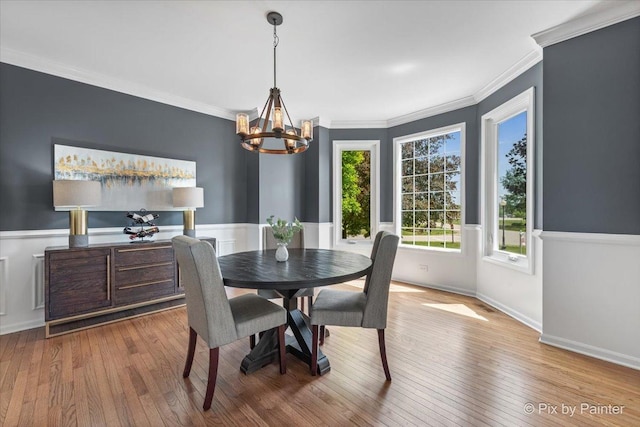 8980 Bardwell Ln, Lakewood, IL 60014 - dining space featuring a chandelier, healthy amount of natural light, wood-type flooring, crown molding, and wainscoting