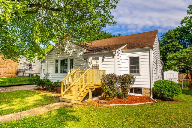 325 Douglas St, Oswego, IL 60543 - bungalow-style house featuring a front yard, a storage shed, and roof with shingles