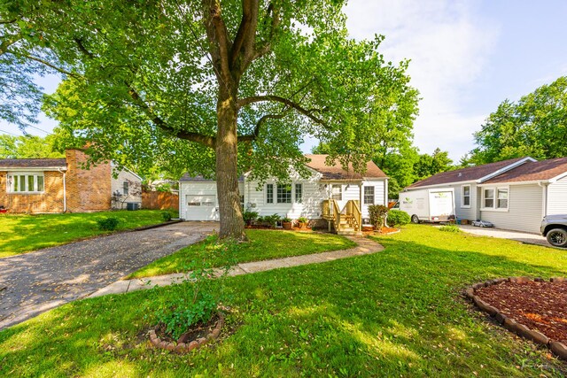 325 Douglas St, Oswego, IL 60543 - view of front of house featuring driveway, a garage, and a front yard