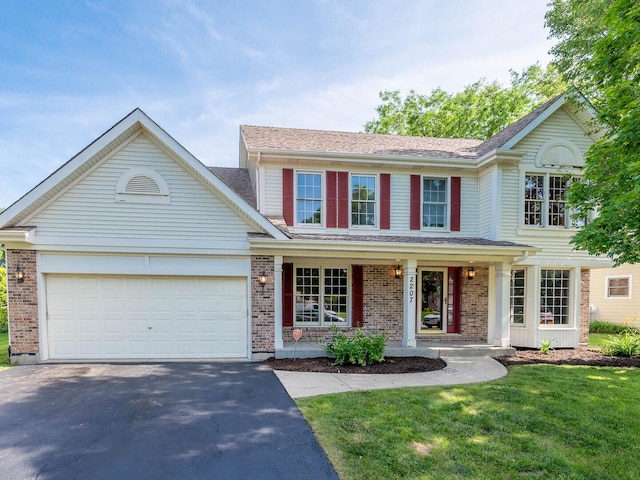 2207 Irvine Ln, Plainfield, IL 60586 - traditional home with driveway, brick siding, covered porch, and a front yard