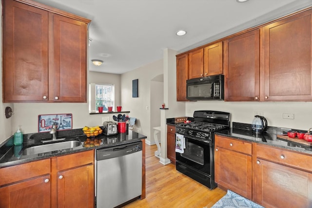 50 Forest Ave Unit 2S, Riverside, IL 60546 - kitchen featuring black appliances, arched walkways, light wood-style flooring, dark stone counters, and recessed lighting