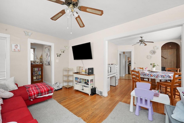 4624 W Montana St, Chicago, IL 60639 - living room featuring ceiling fan, light wood-style flooring, and arched walkways
