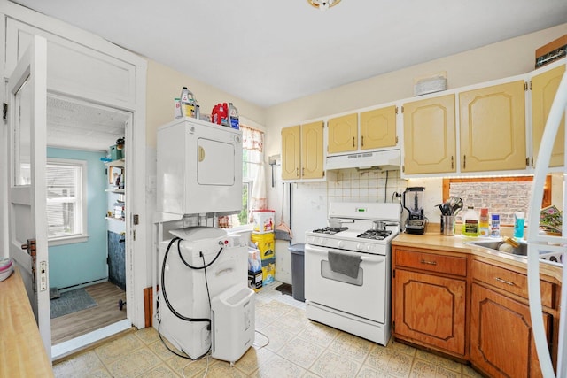 4624 W Montana St, Chicago, IL 60639 - kitchen featuring white gas range oven, stacked washer / drying machine, under cabinet range hood, and healthy amount of natural light