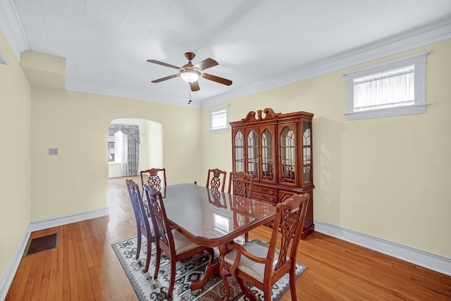 5736 S Honore St, Chicago, IL 60636 - dining space with arched walkways, a ceiling fan, wood-type flooring, and crown molding