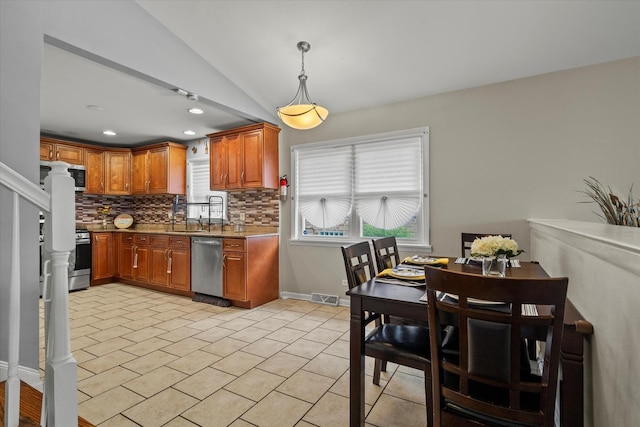 14427 Kenwood Ave, Dolton, IL 60419 - kitchen with appliances with stainless steel finishes, tasteful backsplash, lofted ceiling, brown cabinetry, and decorative light fixtures