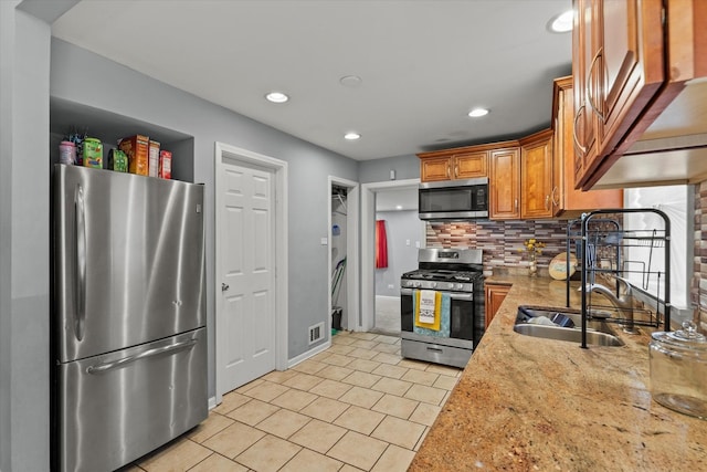 14427 Kenwood Ave, Dolton, IL 60419 - kitchen with stainless steel appliances, tasteful backsplash, light tile patterned floors, recessed lighting, and brown cabinetry