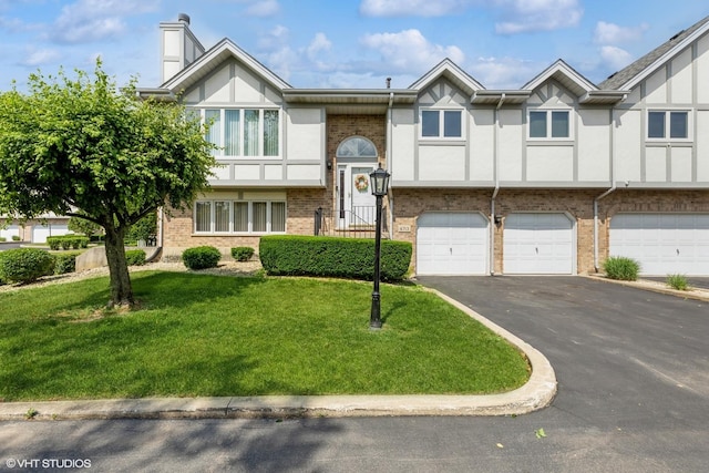 6713 181st St, Tinley Park, IL 60477 - view of front facade featuring asphalt driveway, a front lawn, brick siding, an attached garage, and a chimney