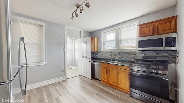 7318 W Archer Ave, Summit, IL 60501 - kitchen featuring appliances with stainless steel finishes, dark countertops, light wood-type flooring, tasteful backsplash, and brown cabinetry