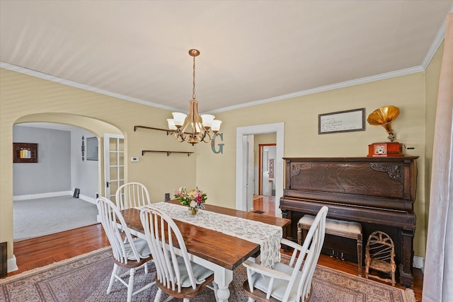835 E Pells St, Paxton, IL 60957 - dining space featuring arched walkways, a chandelier, crown molding, and wood finished floors