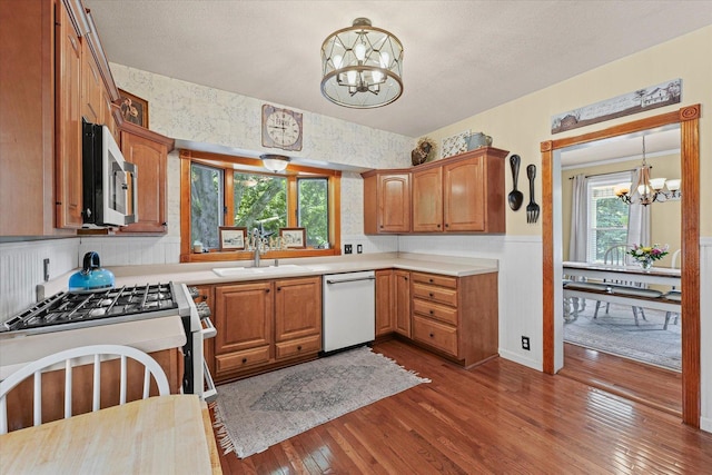 835 E Pells St, Paxton, IL 60957 - kitchen with stainless steel appliances, a chandelier, dark wood finished floors, light countertops, and wainscoting