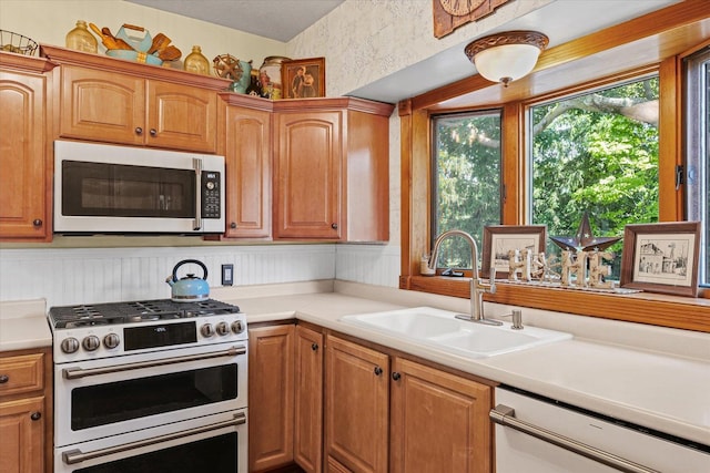 835 E Pells St, Paxton, IL 60957 - kitchen featuring gas range, white dishwasher, light countertops, and brown cabinetry