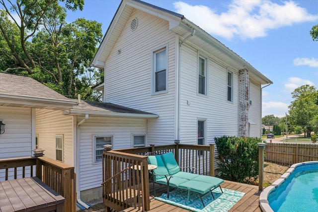835 E Pells St, Paxton, IL 60957 - rear view of property featuring a deck, roof with shingles, and an outdoor pool