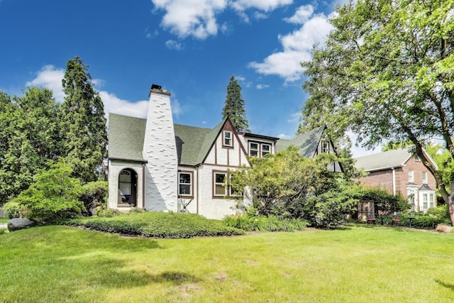 653 Blackstone Pl, Highland Park, IL 60035 - view of front of house with a front yard, a chimney, and a shingled roof
