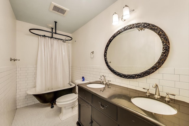 653 Blackstone Pl, Highland Park, IL 60035 - bathroom featuring tile walls, double vanity, wainscoting, shower / bath combination with curtain, and tile patterned floors