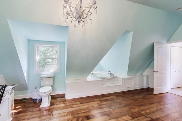 653 Blackstone Pl, Highland Park, IL 60035 - bathroom featuring hardwood / wood-style floors, a chandelier, a bath, and vaulted ceiling