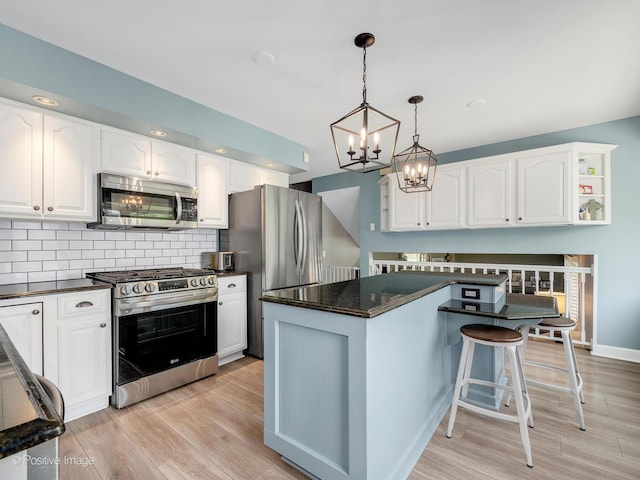 624 63rd St, Downers Grove, IL 60516 - kitchen featuring appliances with stainless steel finishes, a chandelier, white cabinetry, a breakfast bar area, and light wood finished floors
