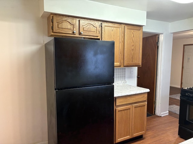 2841 10th St, Rockford, IL 61108 - kitchen featuring black appliances, light wood-type flooring, and decorative backsplash