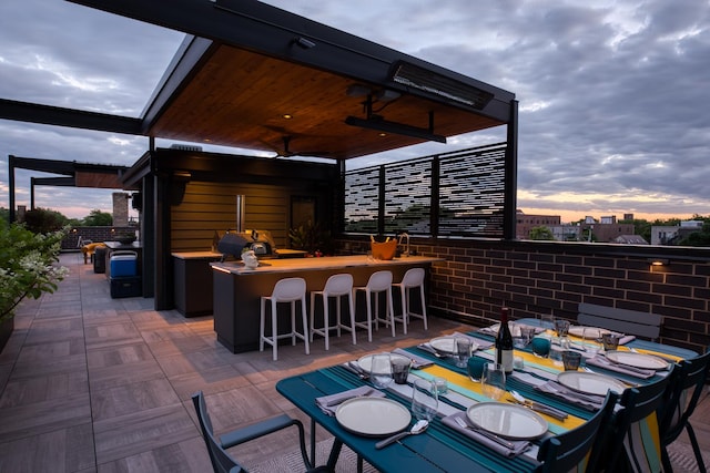 1469 W Byron St Unit 2, Chicago, IL 60613 - patio terrace at dusk with a bar, ceiling fan, a patio, and area for grilling