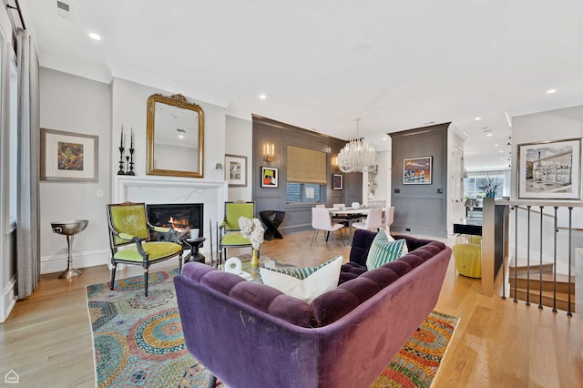 1469 W Byron St Unit 2, Chicago, IL 60613 - living area with a chandelier, a glass covered fireplace, ornamental molding, light wood finished floors, and recessed lighting
