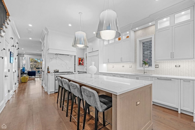 1469 W Byron St Unit 2, Chicago, IL 60613 - kitchen featuring a center island, decorative backsplash, light wood-style flooring, white cabinets, and recessed lighting