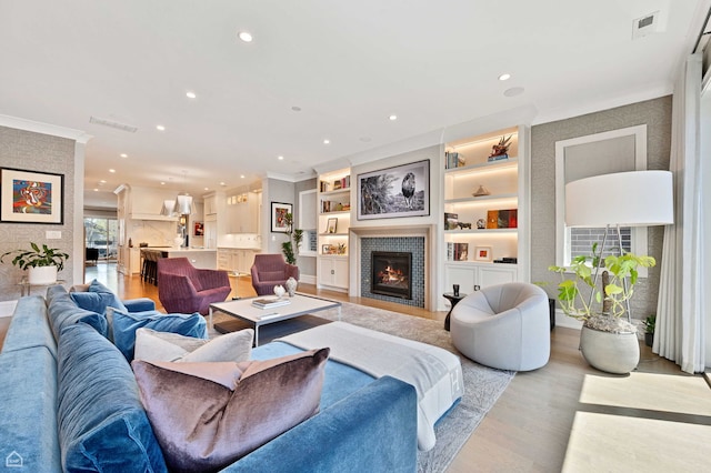 1469 W Byron St Unit 2, Chicago, IL 60613 - living room with ornamental molding, recessed lighting, light wood-style flooring, a fireplace, and built in shelves