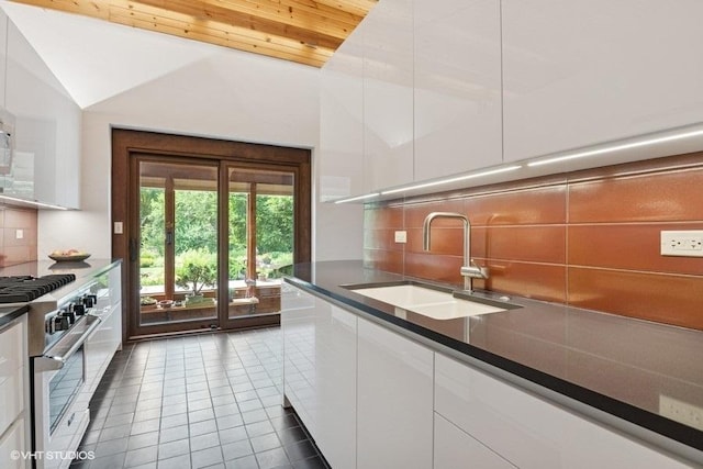 41W955 Northway Dr, Elburn, IL 60119 - kitchen featuring stainless steel stove, white cabinets, tile patterned flooring, tasteful backsplash, and lofted ceiling