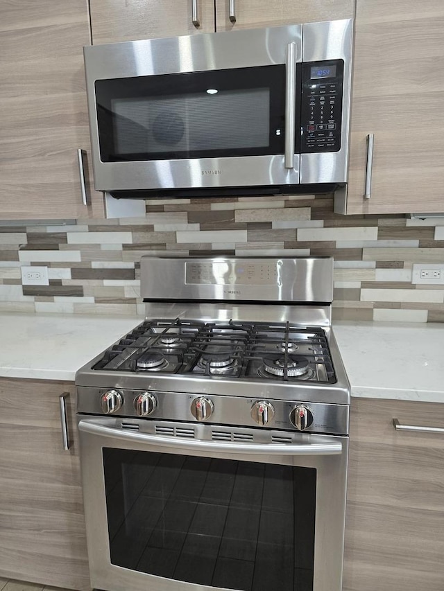 1441 E Thacker St Unit 501, Des Plaines, IL 60016 - kitchen view of stainless steel appliances, decorative backsplash, modern cabinets, and light stone countertops