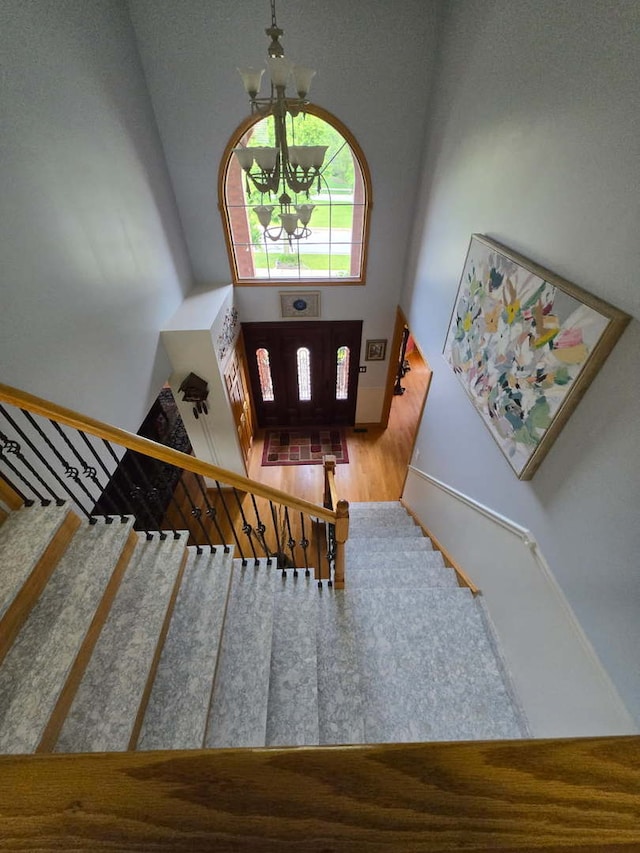 22450 Autumn Dr, Frankfort, IL 60423 - stairs featuring a high ceiling, a chandelier, and wood finished floors