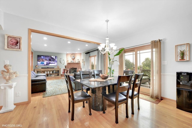22450 Autumn Dr, Frankfort, IL 60423 - dining area with light wood-type flooring, a chandelier, recessed lighting, and a fireplace