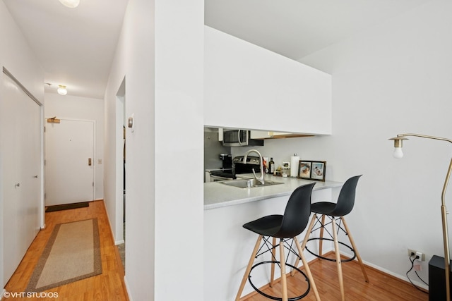 740 S Federal St Unit 1106, Chicago, IL 60605 - kitchen with light wood finished floors, light countertops, a kitchen breakfast bar, stainless steel microwave, and a peninsula