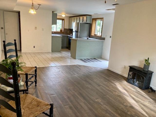 6102 E Hillside Rd, Crystal Lake, IL 60012 - kitchen featuring freestanding refrigerator, healthy amount of natural light, a wood stove, and light wood-style flooring