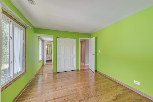 4524 Kings Walk Dr Unit 2A, Rolling Meadows, IL 60008 - unfurnished bedroom with multiple windows, light wood-style floors, and a closet