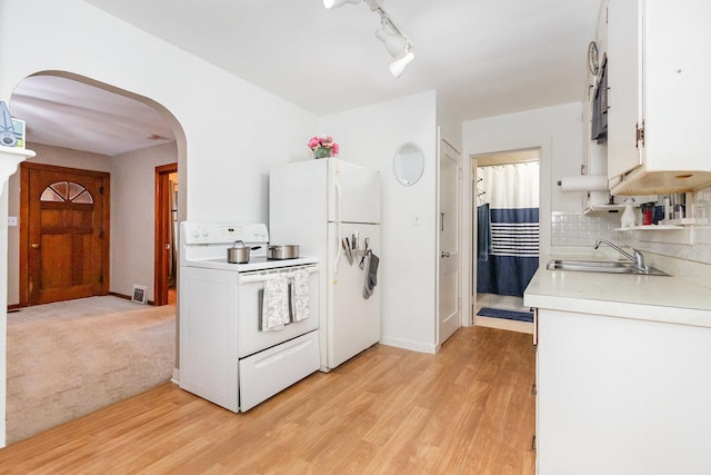 1814 E Washington St, Joliet, IL 60433 - kitchen featuring white appliances, light countertops, arched walkways, tasteful backsplash, and white cabinets
