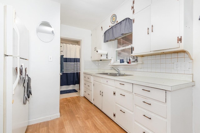 1814 E Washington St, Joliet, IL 60433 - kitchen featuring freestanding refrigerator, light countertops, light wood-style floors, backsplash, and white cabinets